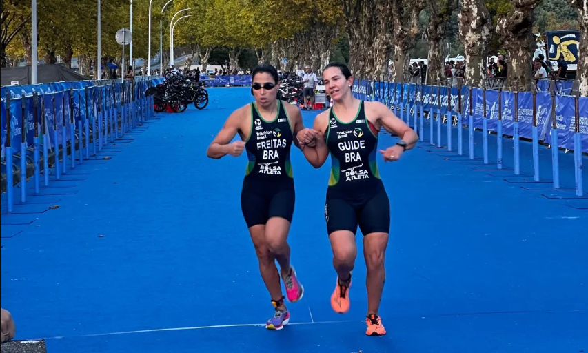 Na imagem, Letícia Freitas, umas das medalhistas do Brasil, conduzida pela atleta-guia.