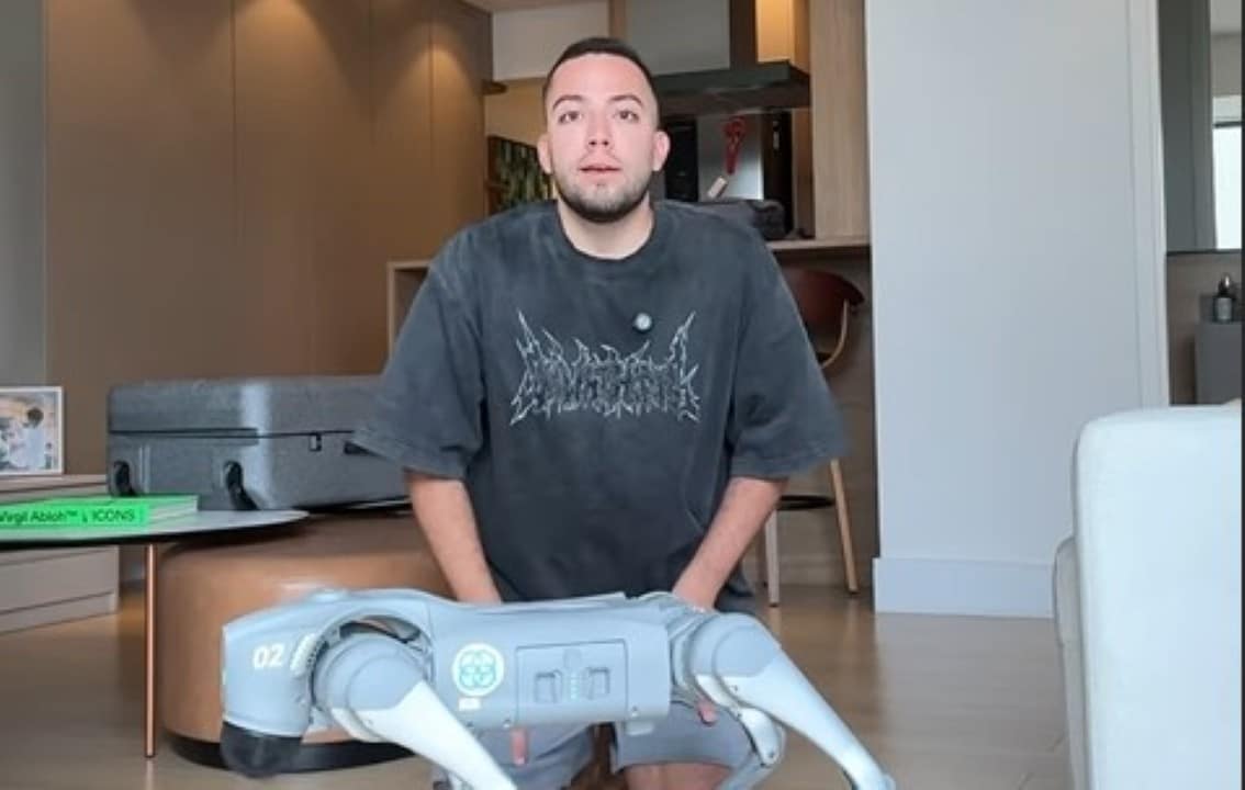 Lucas Rangel com cão robótico