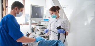 Médico realiza exame de colonoscopia em paciente durante procedimento hospitalar