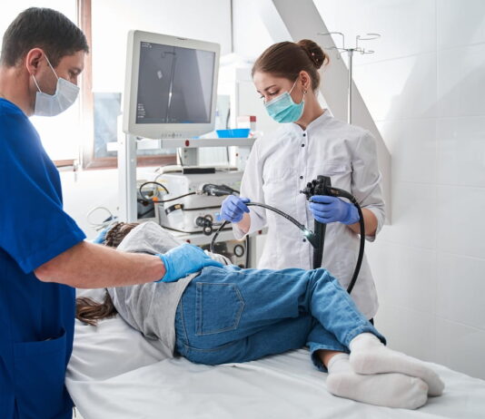 Médico realiza exame de colonoscopia em paciente durante procedimento hospitalar