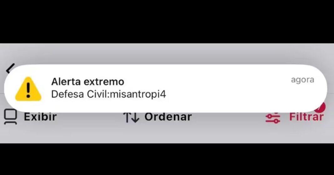 Celular exibindo alerta falso da Defesa Civil no Acre com elementos de segurança digital ao fundo
