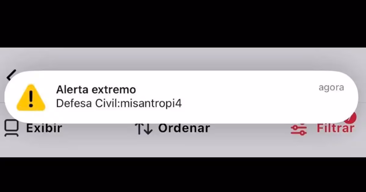 Celular exibindo alerta falso da Defesa Civil no Acre com elementos de segurança digital ao fundo